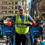 Citi Bike Senior Driver Ed Avilez removes two bikes from the racks at Broadway and West 24th Street in Flatiron, Manhattan. The Citi Bike docking station will soon move across 24th Street to free up pedestrian space.</br>